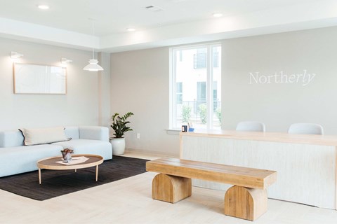 A reception area with a white couch, wooden bench, and a plant.