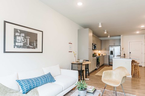 A white couch with a blue pillow sits in a living room.