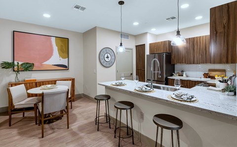 A kitchen with a bar area and a dining table set up.