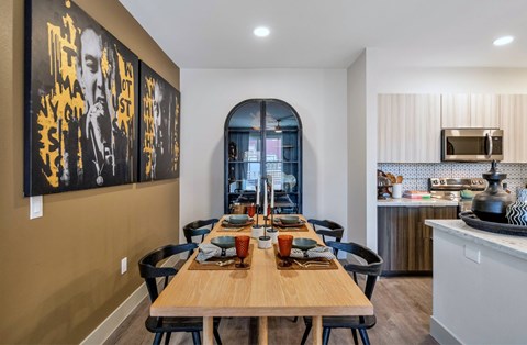 A dining room with a wooden table set for a meal.