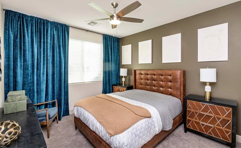 A bedroom with a large bed and a ceiling fan.