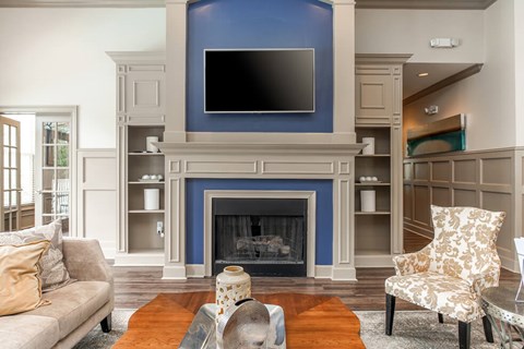 A living room with a fireplace and a television above it.