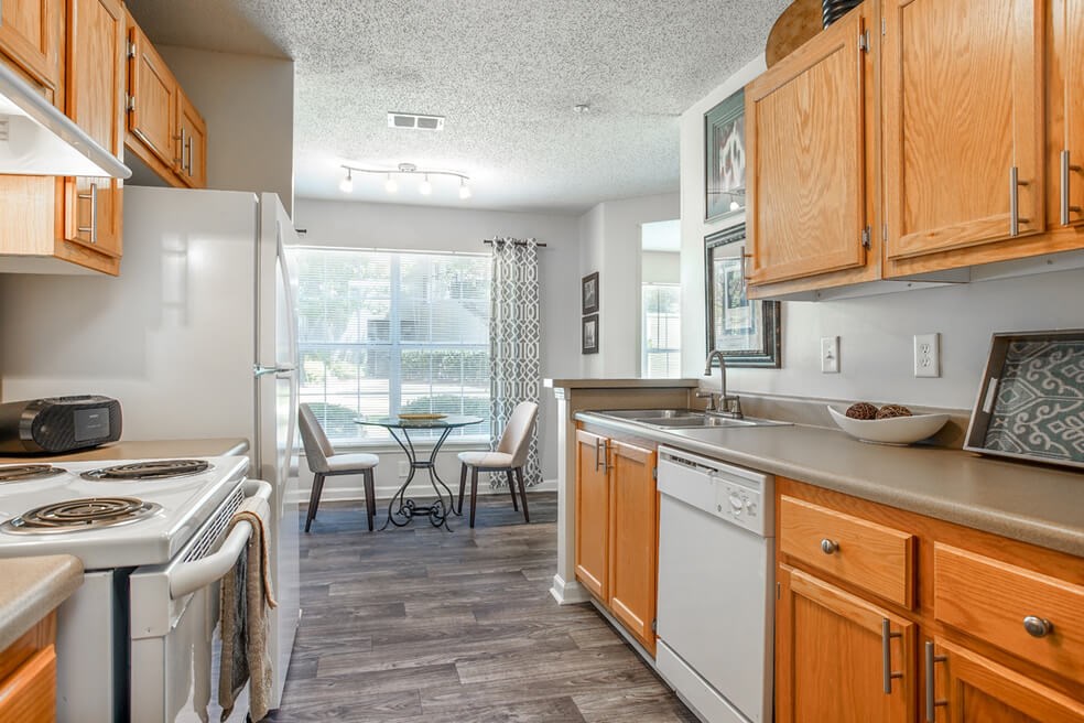 A kitchen with wooden cabinets and a white refrigerator.at Monterey Village, Georgia
