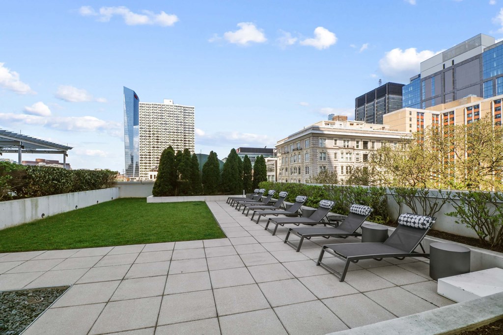 A rooftop patio with several chairs and a table.