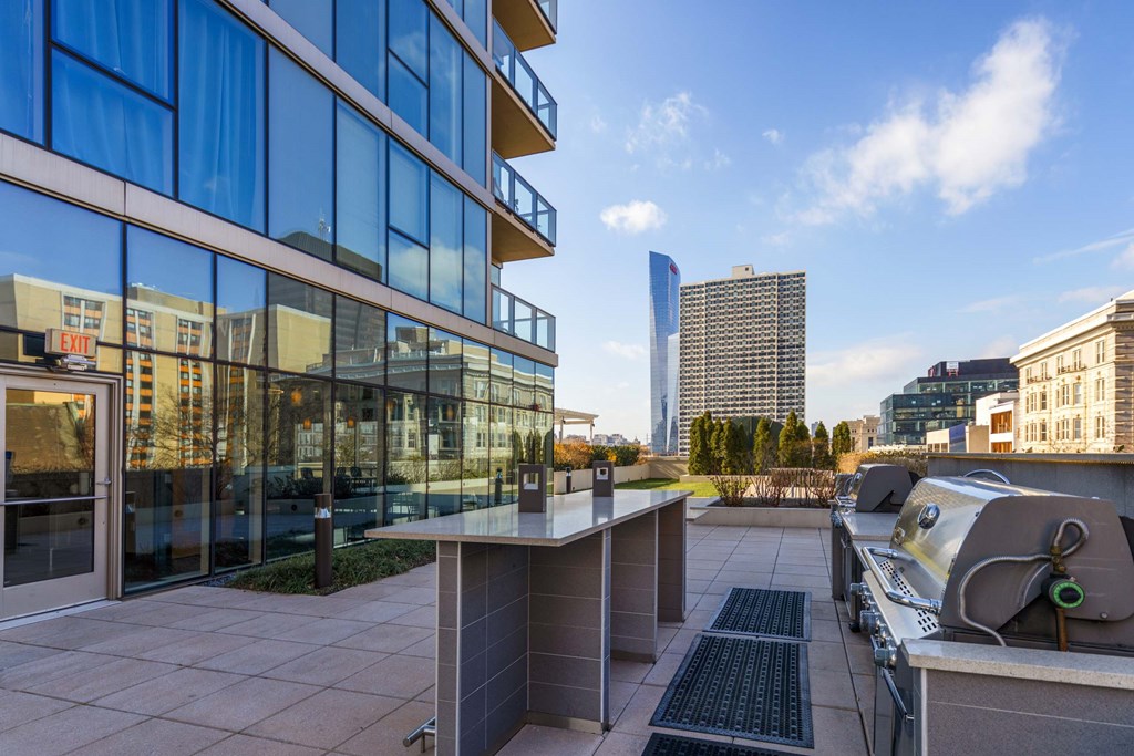 A modern building with a glass facade and a rooftop terrace.