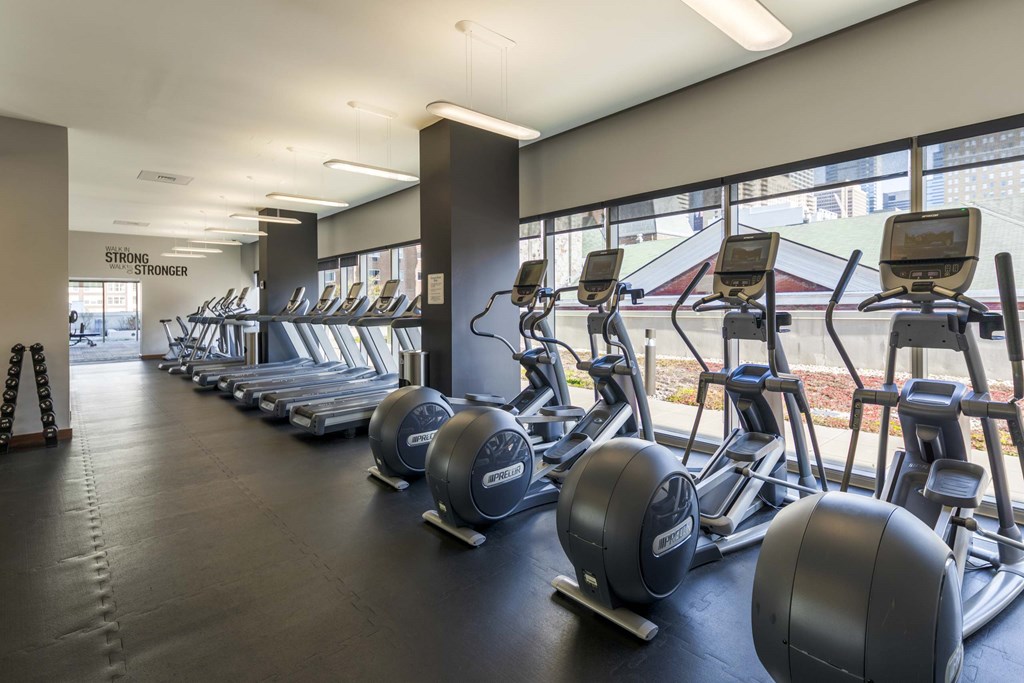 A gym with a row of exercise bikes and a sign that says "Strength Stronger".