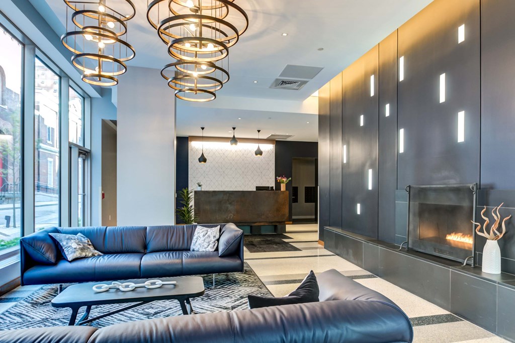 A modern living room with a blue couch and a fireplace.