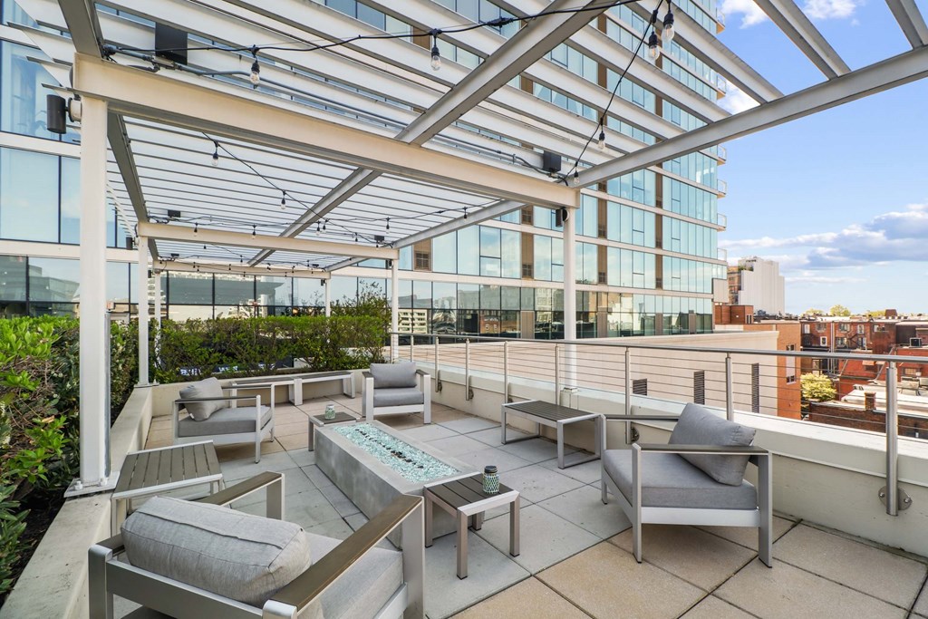 A rooftop patio with a table and chairs.