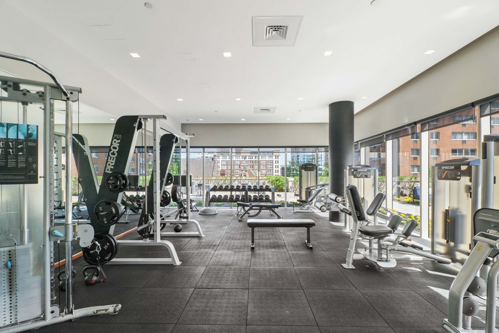 A gym with a variety of equipment including weights and cardio machines.