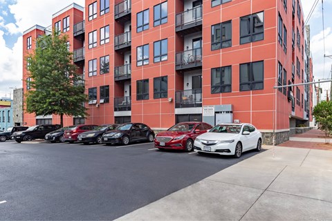 A red building with cars parked in front.