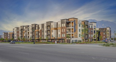 A row of modern apartment buildings with a mountain in the background.
