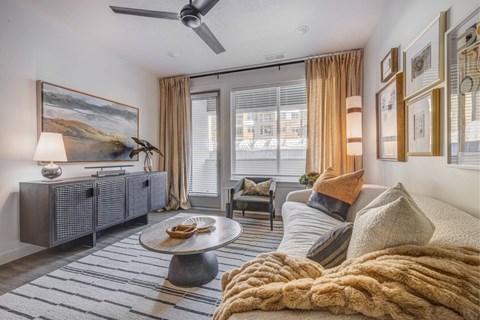 A living room with a large couch and a painting on the wall.
