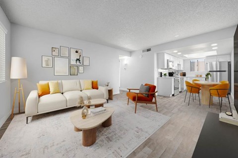 A living room with a white couch and orange accents.