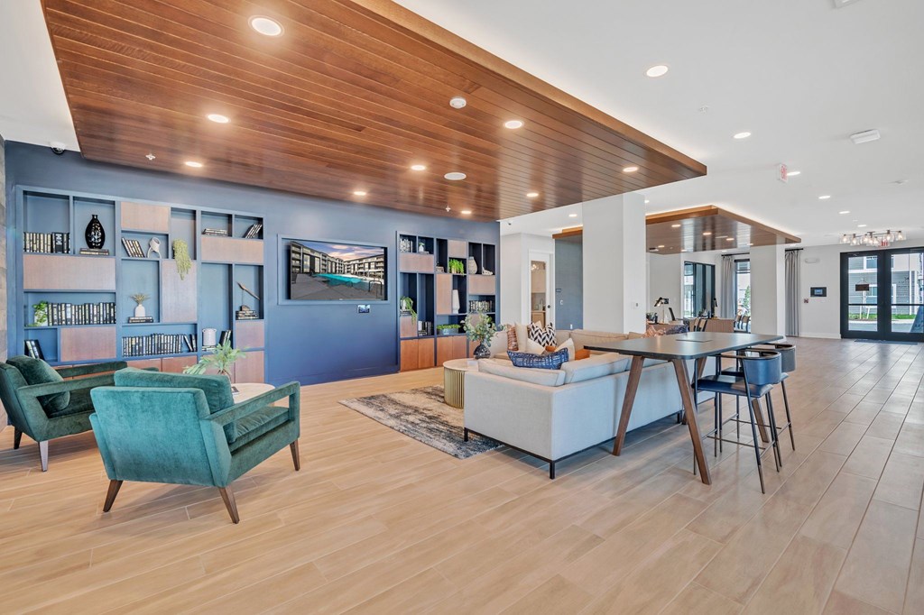 A modern living room with a wooden ceiling and a dining table set up.