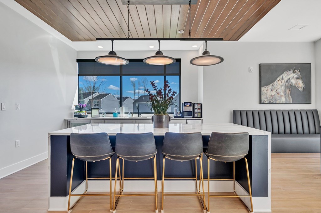 A kitchen with a bar area and three bar stools.