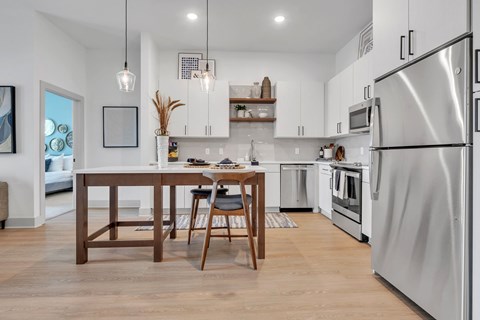 A modern kitchen with a wooden table and chairs.
