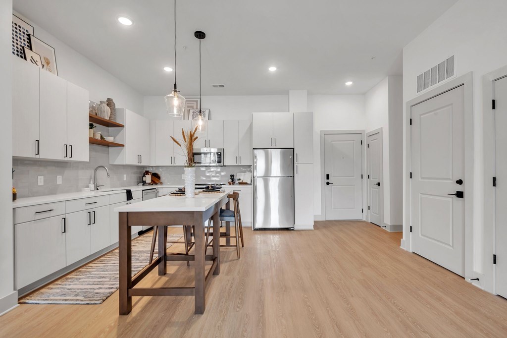 A modern kitchen with a wooden table and chairs.