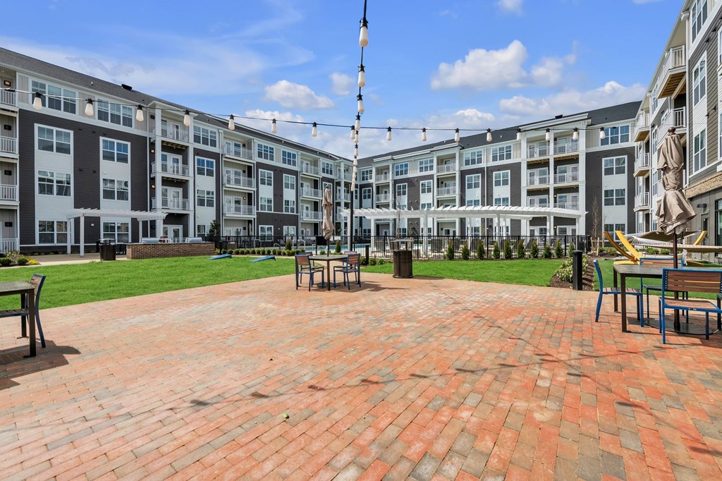 A courtyard with a statue and benches in front of apartment buildings.