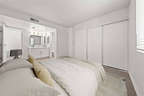 Bedroom with bed, dresser, and a mirror at Station 21 apartments for rent in Mesa.
