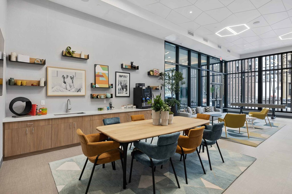 A modern office space with a long table surrounded by chairs.