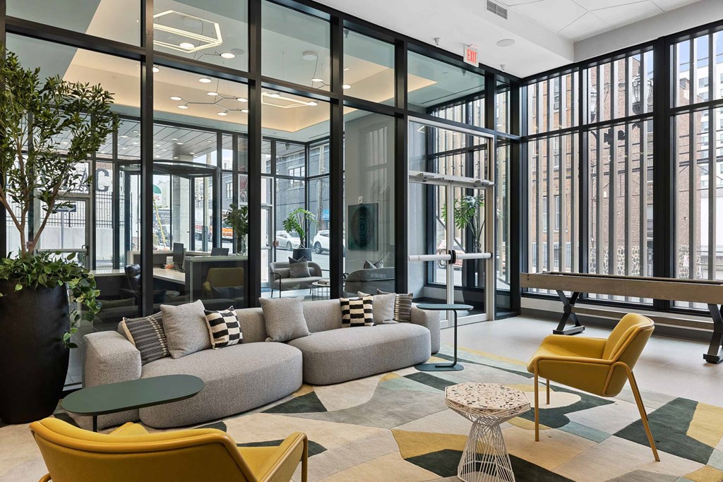 A modern living room with a yellow chair and a grey sofa.