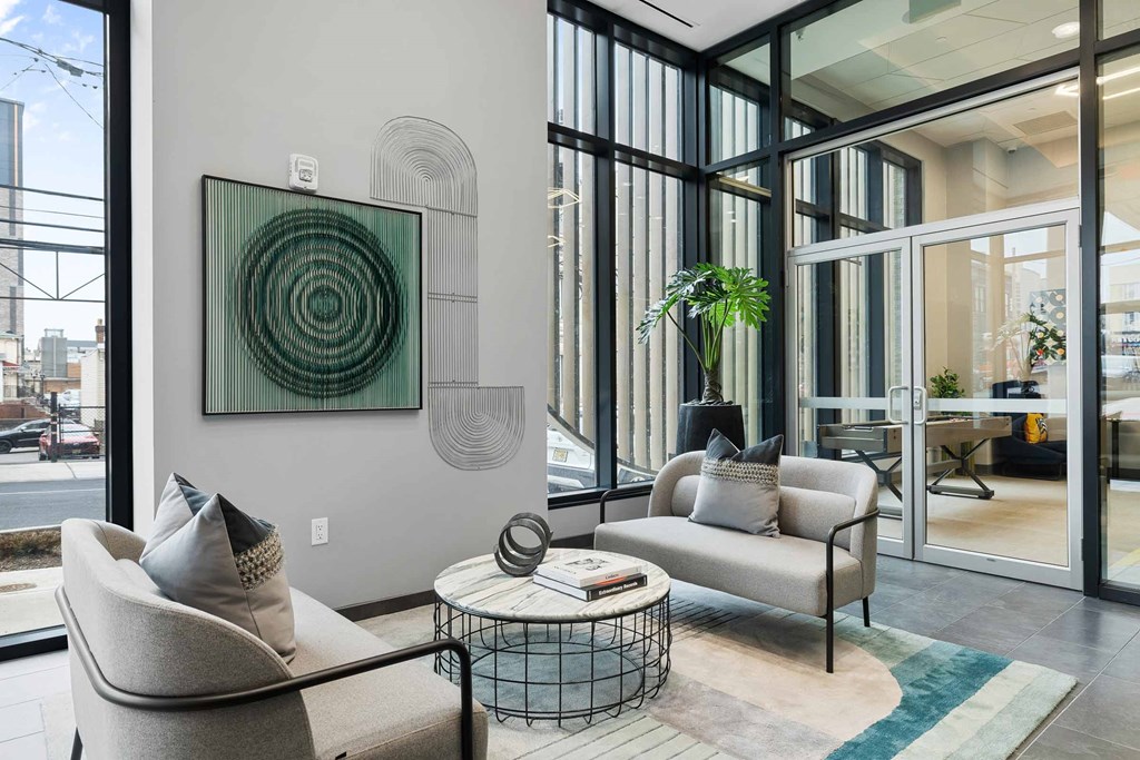 A living room with a large painting on the wall and a couch.