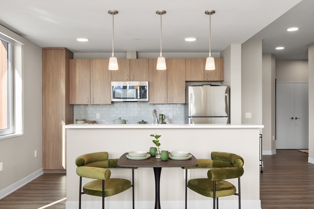 A kitchen with a table and chairs in the foreground.