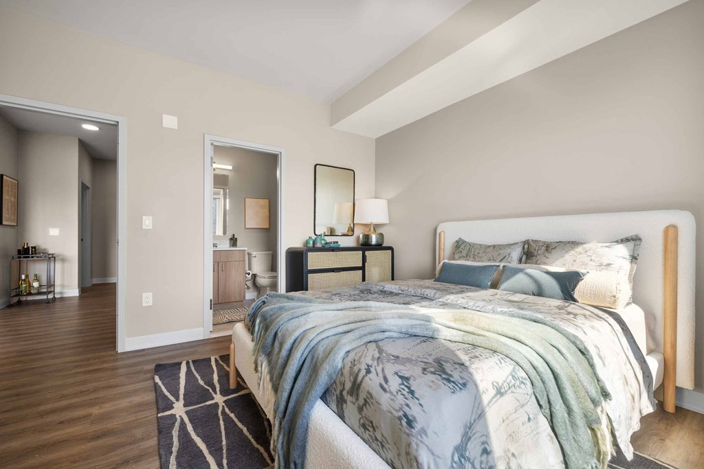 A bedroom with a large bed and a mirror on the wall.