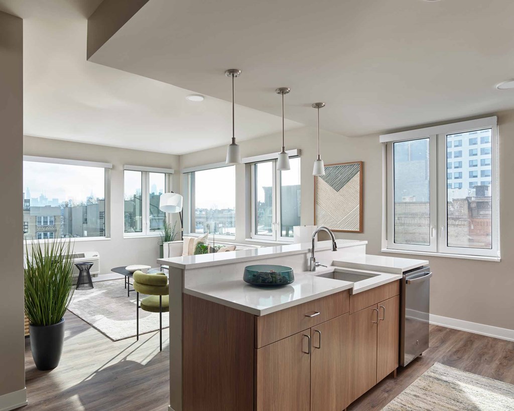 A modern kitchen with a large island and pendant lights.