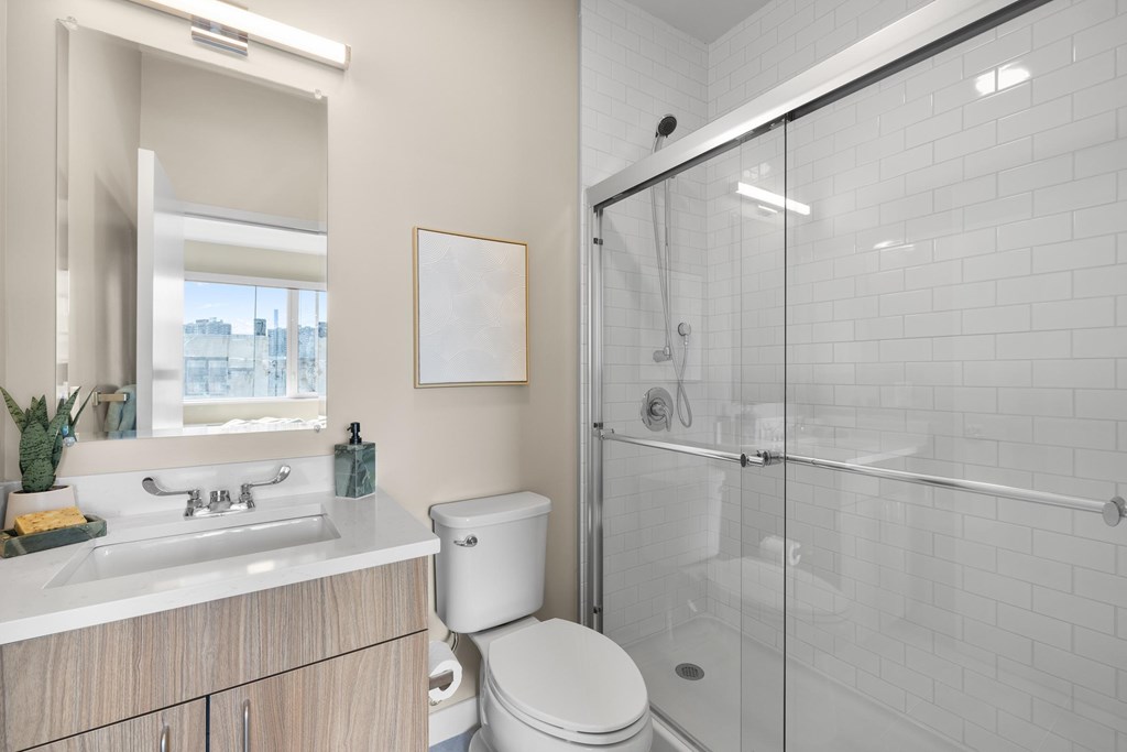 A white toilet sits next to a sink in a modern bathroom.