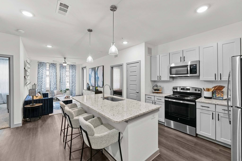 A modern kitchen with a long island and bar stools.