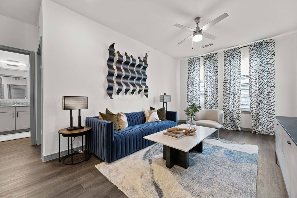 A living room with a blue sofa and a wooden table.