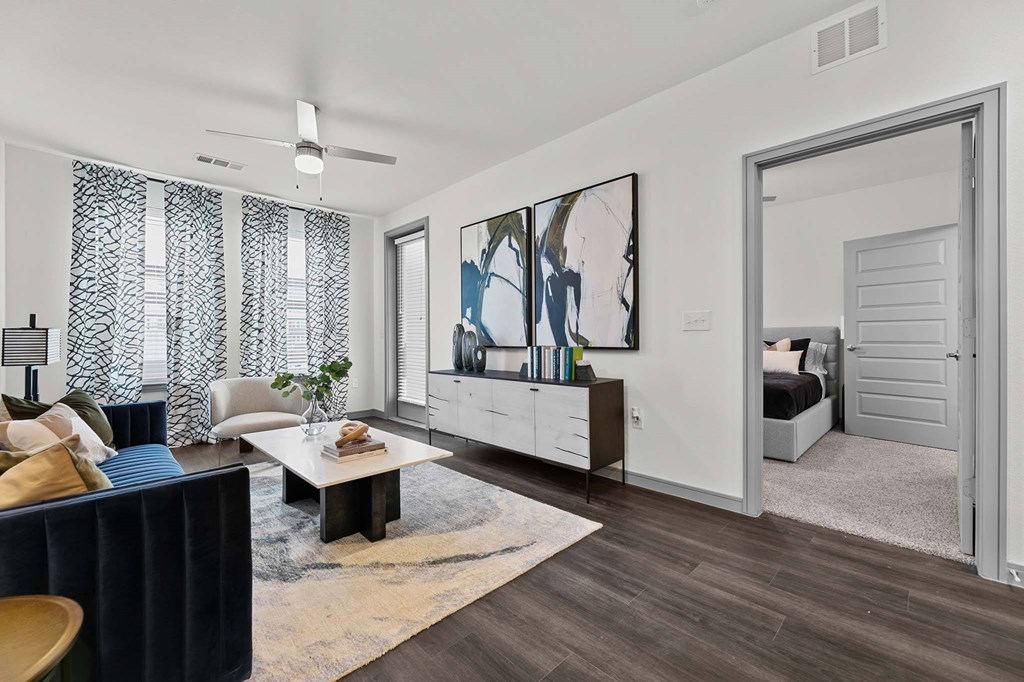 A living room with a blue sofa, a coffee table, and a painting on the wall.