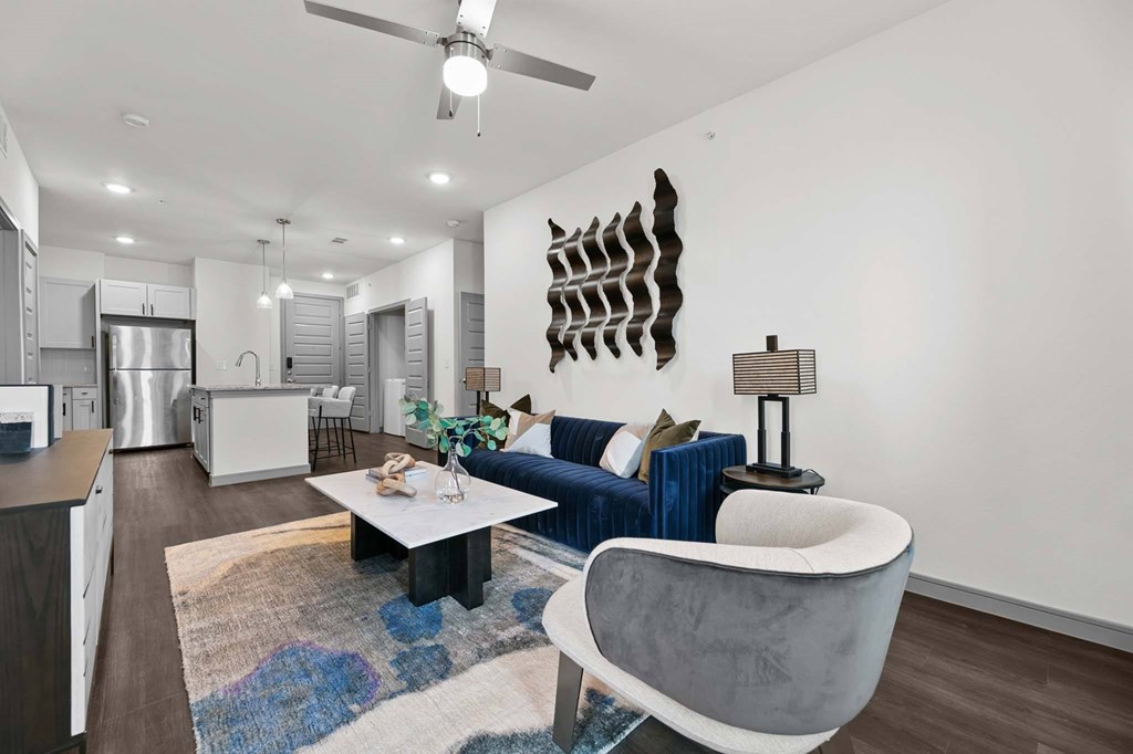 A modern living room with a blue couch and a white coffee table.
