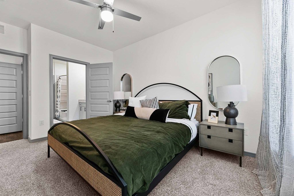 A bedroom with a bed, nightstand, and a ceiling fan.