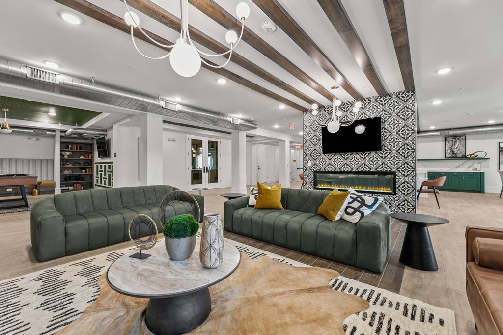 A living room with a green sofa and a television on the wall.