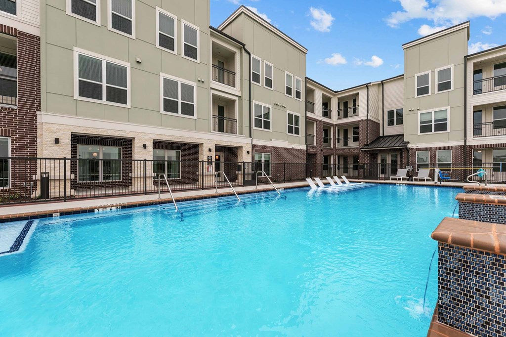 A swimming pool in front of apartment buildings.