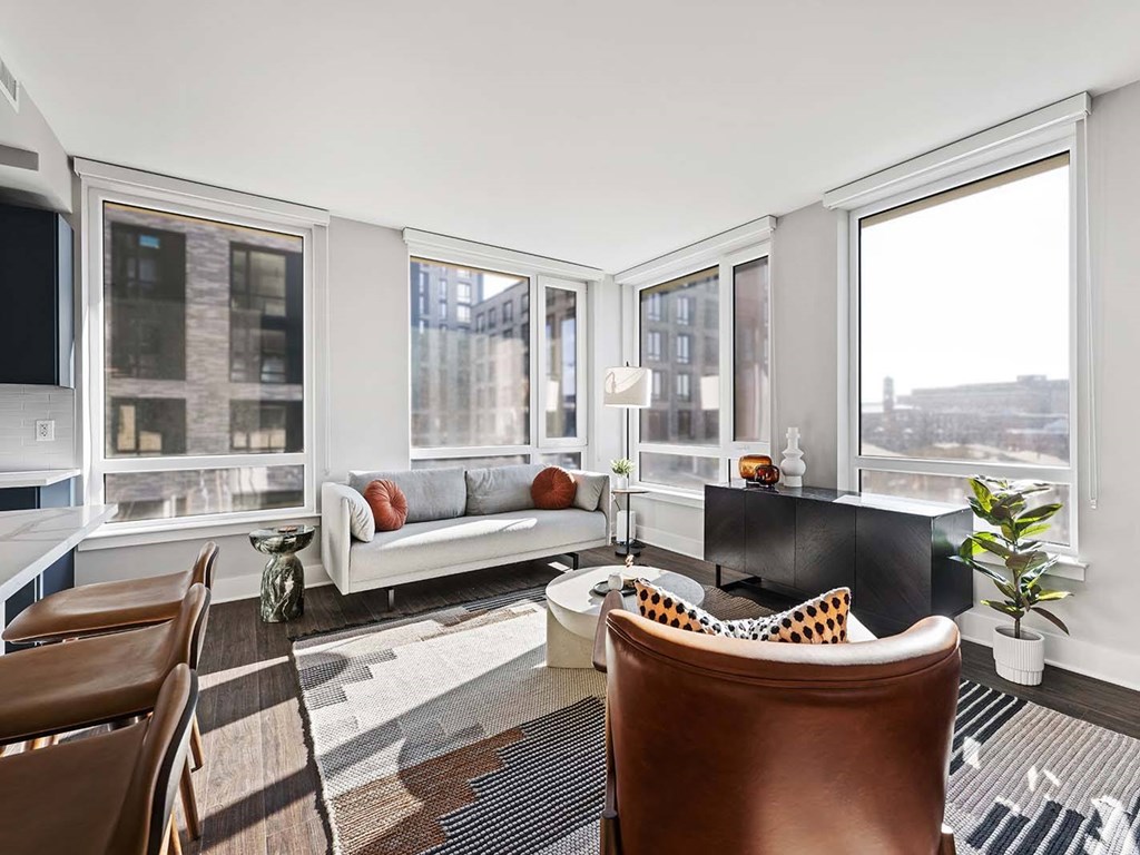A living room with a brown leather chair and a white sofa.