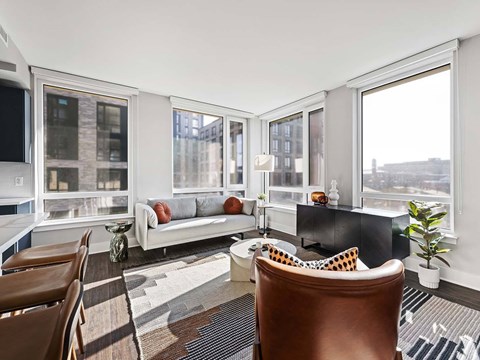 A living room with a brown leather chair and a white sofa.