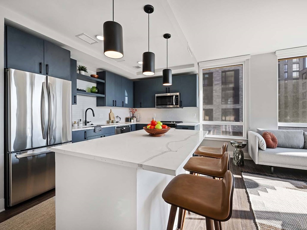 A modern kitchen with a white island and brown bar stools.