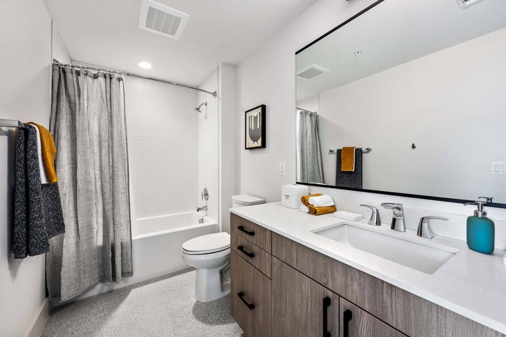 A bathroom with a white toilet, a sink, and a mirror.
