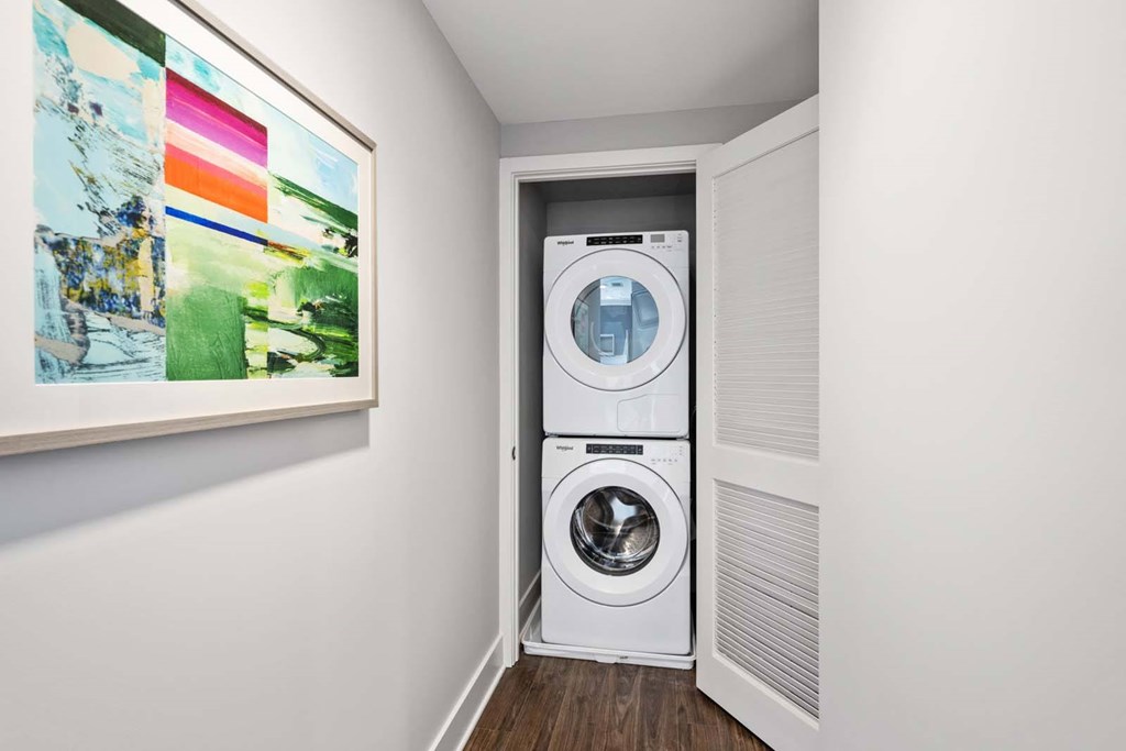 A white front loading washing machine in a laundry room.