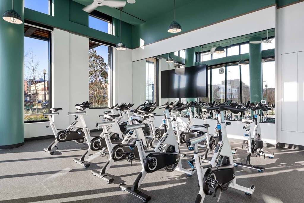 A gym with a row of stationary bikes.