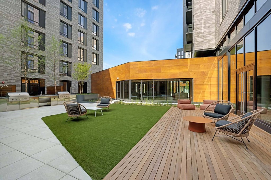 A modern outdoor seating area with a wooden deck and chairs.