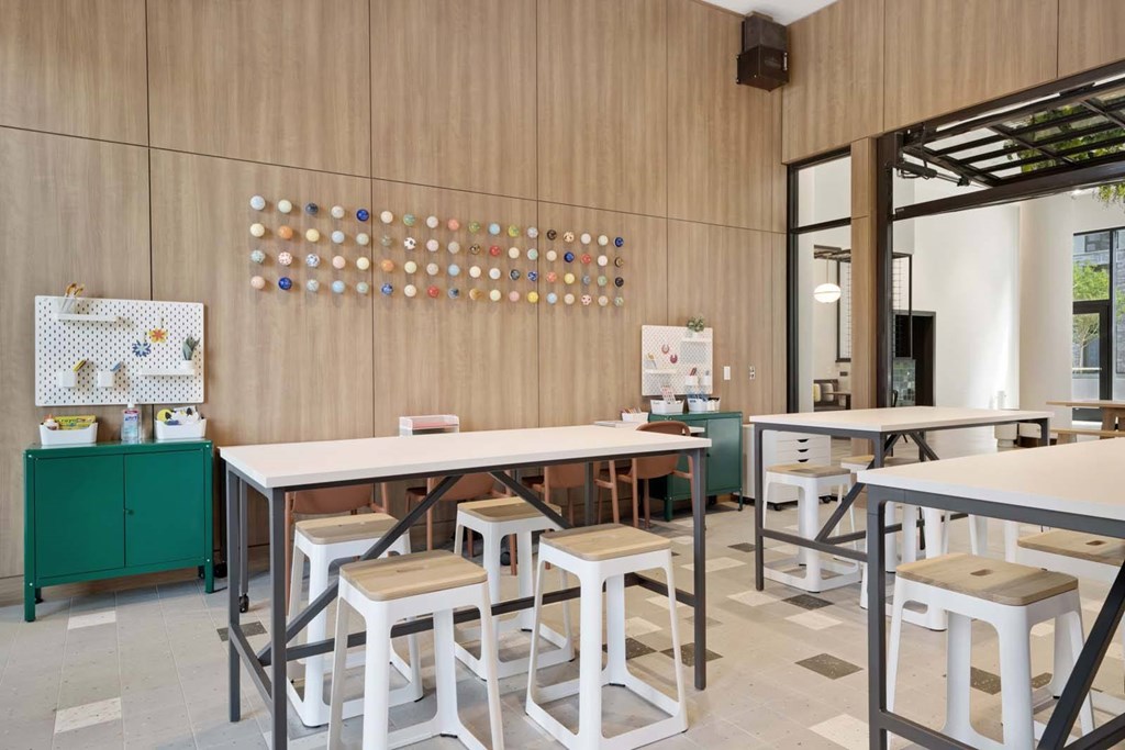 A modern dining area with a long table and white chairs.
