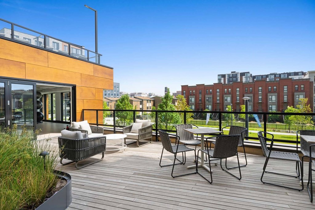 A patio with a table and chairs overlooking a cityscape.