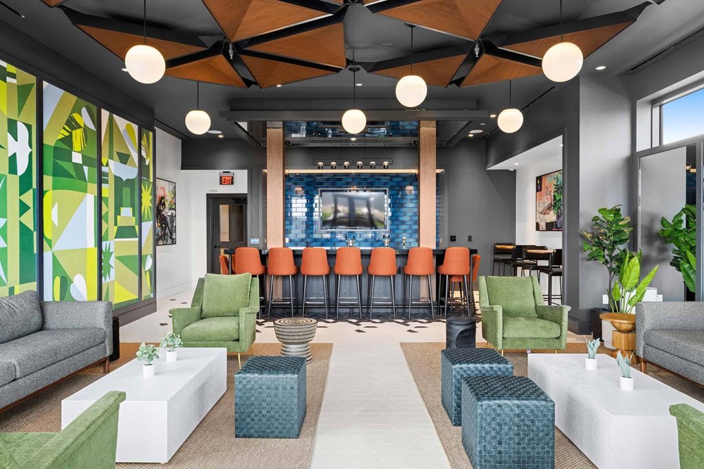 A modern living room with a bar area in the background.