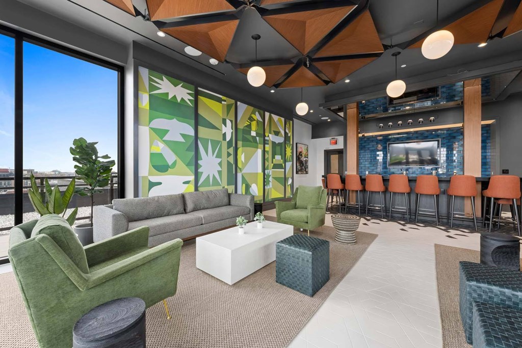 A modern living room with a green armchair and a grey sofa.