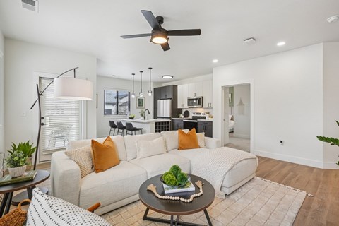 A modern living room with a white sofa and a coffee table in the center.
