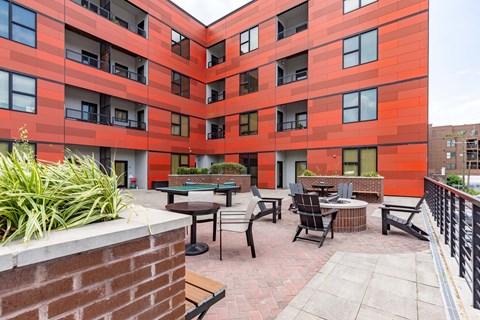 A red building with a patio and chairs.